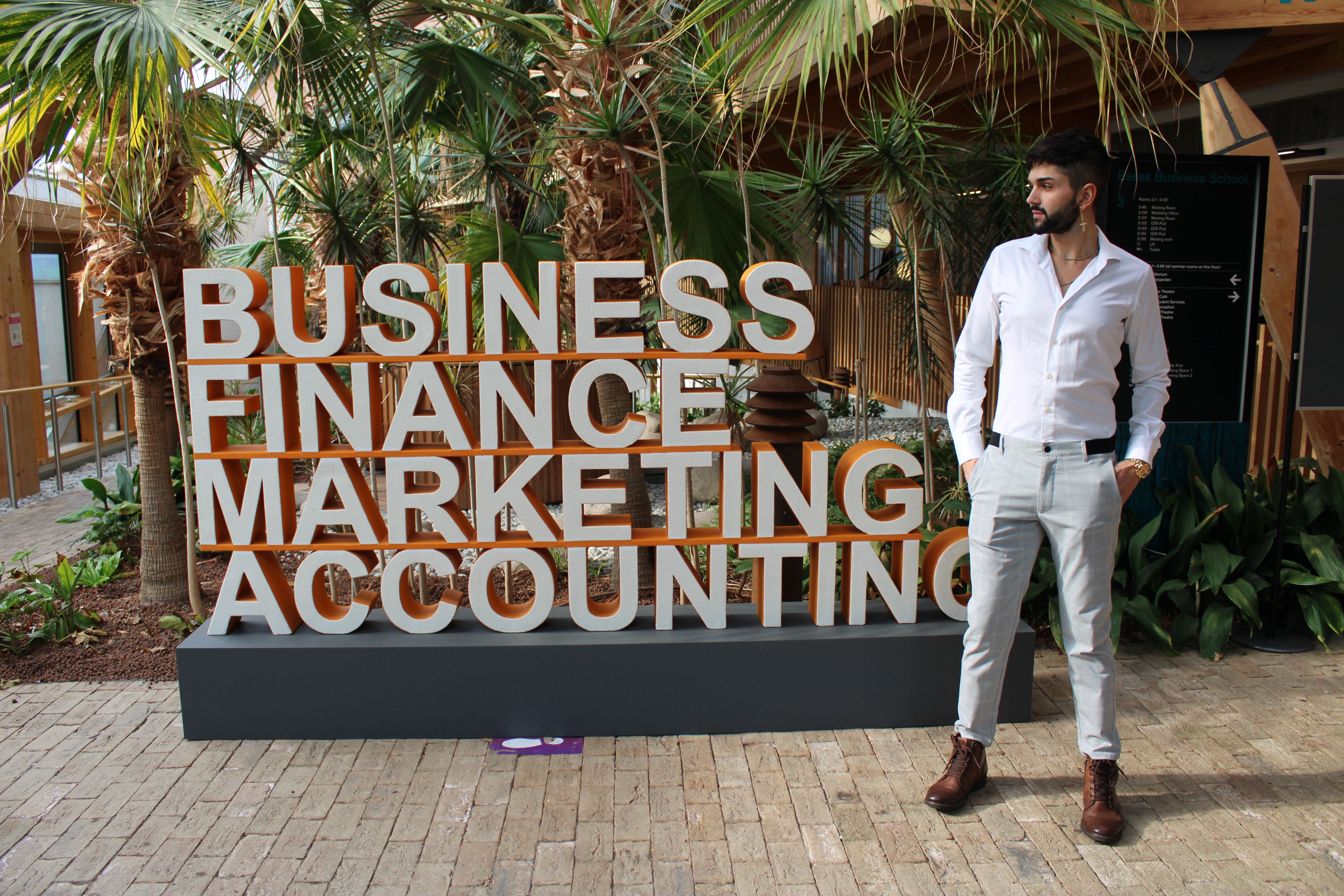 Michael stood next to a sign that reads "business, finance, marketing and accounting"