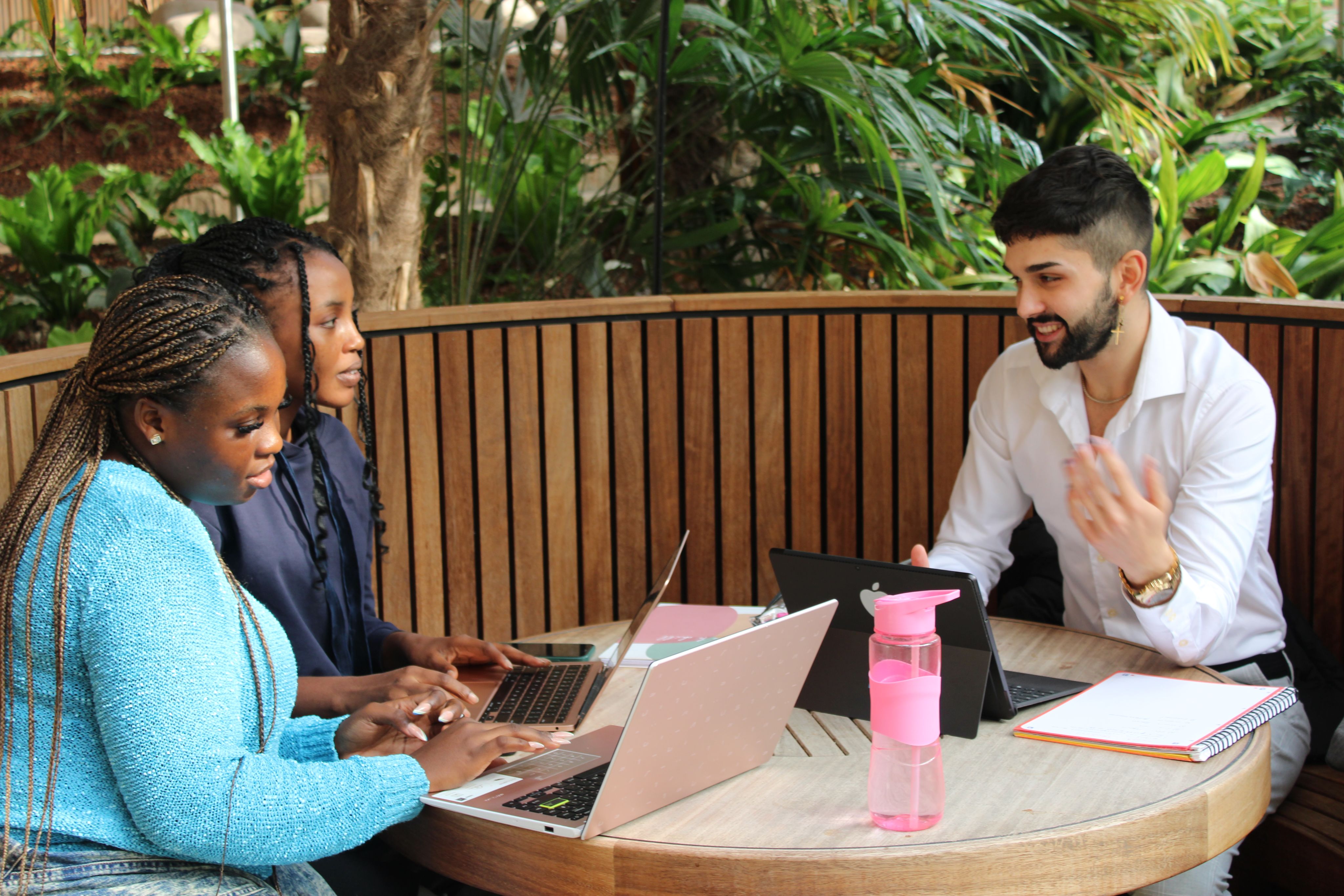 Michael sat with 2 female students in one of the pods in the Essex Business School winter garden